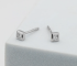 Princess-cut lab grown diamond stud earrings in a bezel setting, displayed on a light grey foam stand.