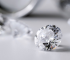 Polished cushion-cut lab grown diamond on a light grey surface, illustrating the stone to be cleaned in a care guide.