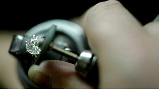 Lab grown diamond being set into a ring with a jeweling tool.
